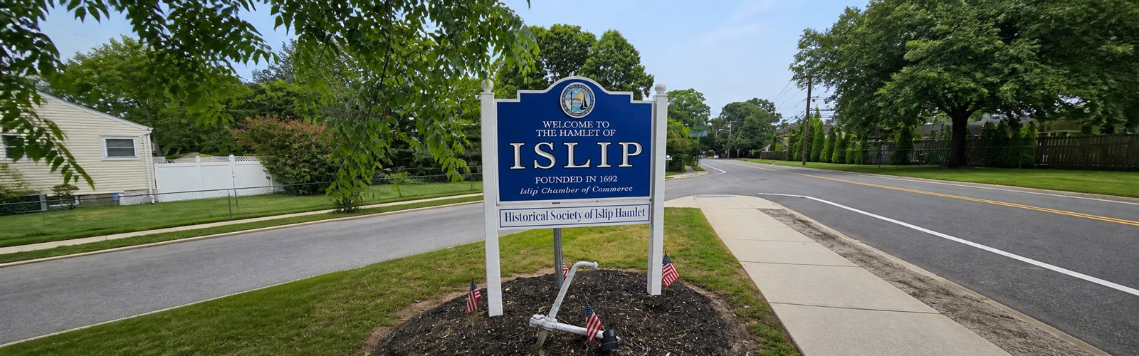 Welcome to the Hamlet of Islip sign along a quiet residential road in Islip, New York