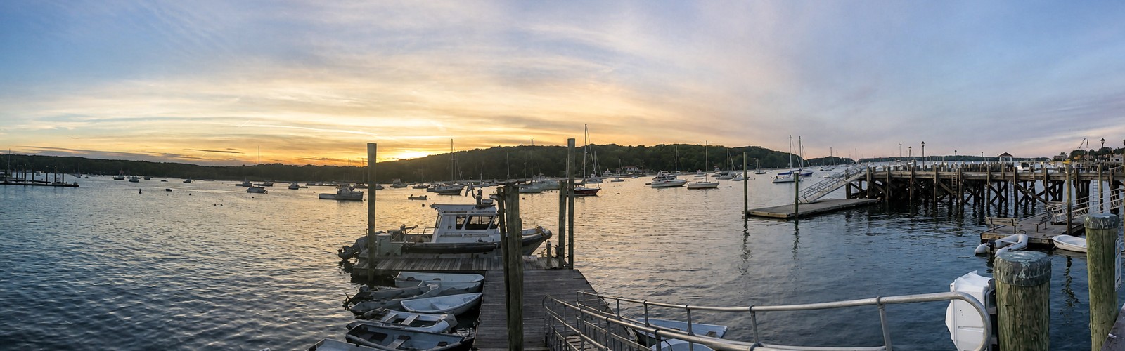 Northport Harbor at sunset with boats and waterfront docks in Northport, New York